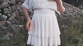 Lovely girl in a white dress pissing outdoors