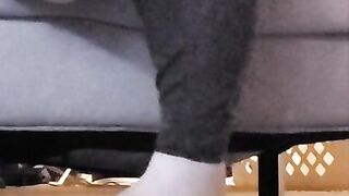 Taking off shoes after long day rubbing stinky feet in sweaty white socks