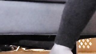 Taking off shoes after long day rubbing stinky feet in sweaty white socks