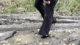 girl in high-heeled boots wants to go to home, but there is dirty slippery slide on the way
